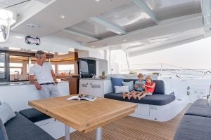 Family relaxing on Lagoon 46 catamaran cockpit with table