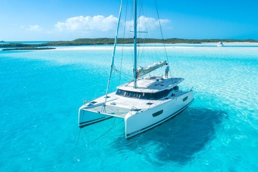 Catamaran Dream Yacht ancré dans des eaux bleues et transparentes.