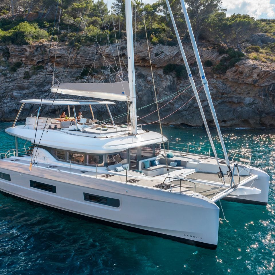 Catamaran à voile de luxe Lagoon 60 au mouillage près d’un rivage accidenté