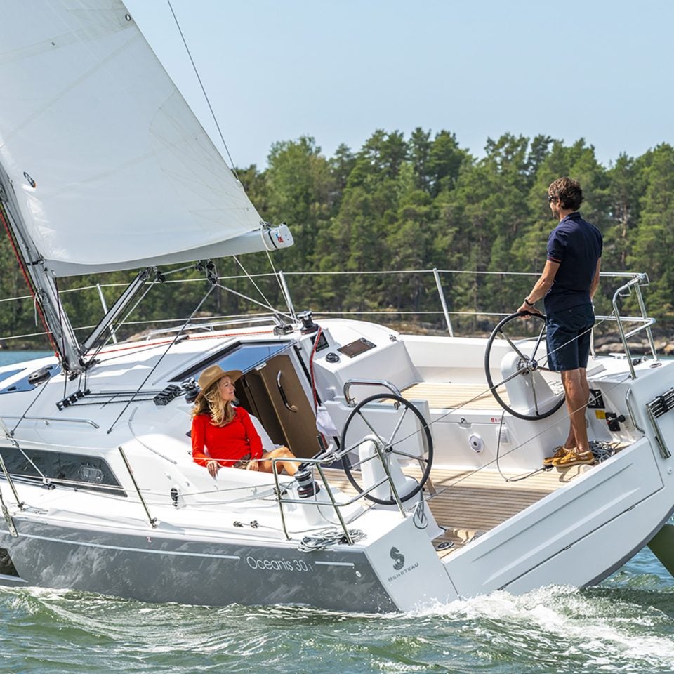 Barca a vela Beneteau 30.1 con vele spiegate e uomo al timone