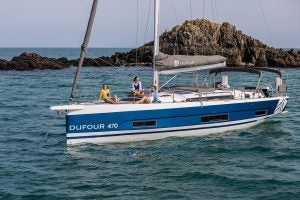 Velero eléctrico Dufour 470 anclado con gente en la proa