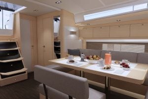 Mesa de comedor y escalerilla en el interior del barco de navegación eléctrica Dufour 470