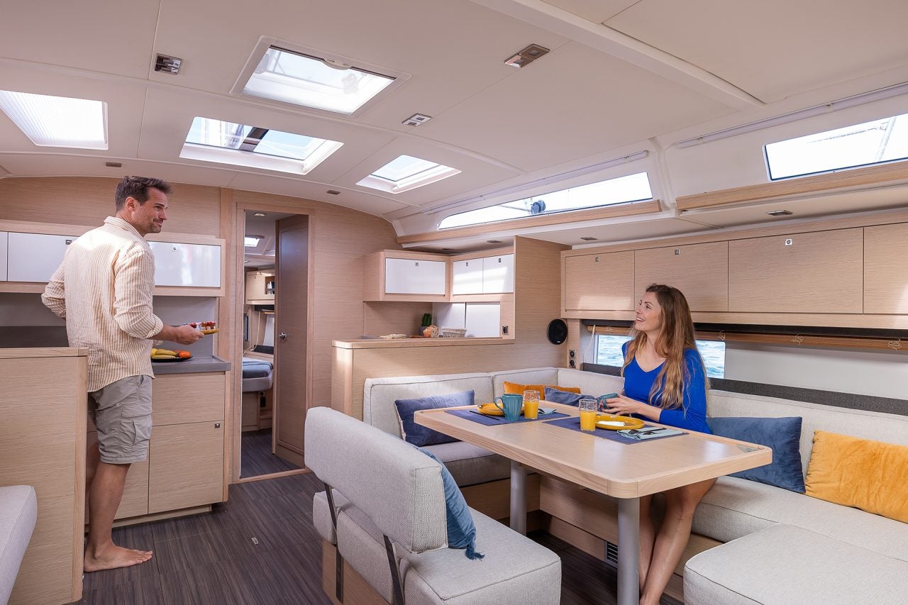 Couple using Dufour 470 sailing monohull kitchen and dining area