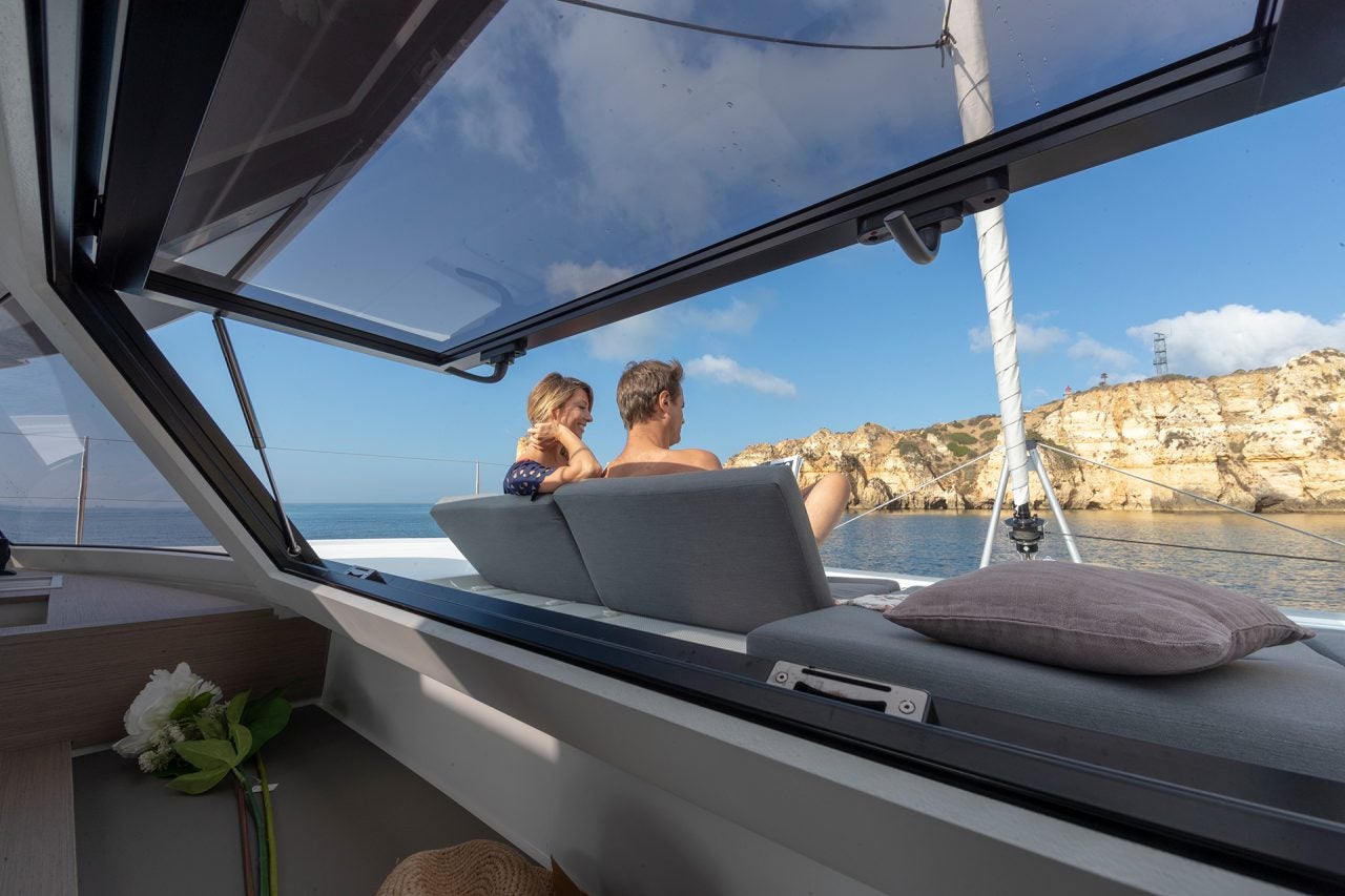 Couple dans le salon sur le pont avant du catamaran Fountaine Pajot Elba 45