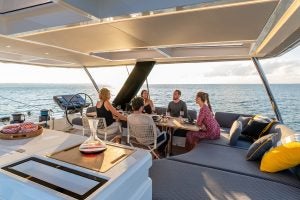 Gruppo di persone al tavolo da pranzo del catamarano Lagoon 65