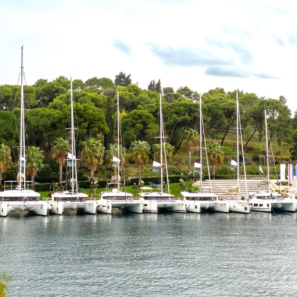 Flota de catamaranes a vela de Dream Yacht atracados a lo largo de un muelle.