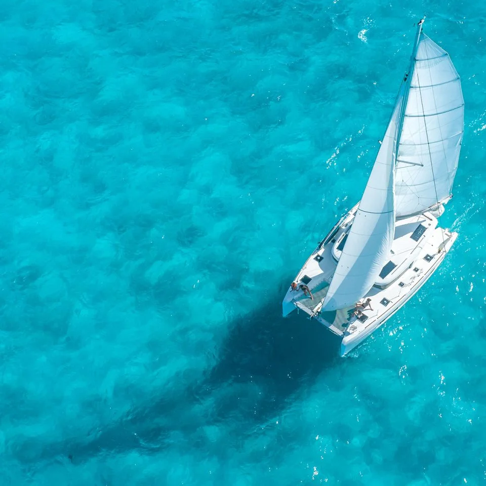 Dream Yacht birdseye view of catamaran sailing in clear, bright blue water