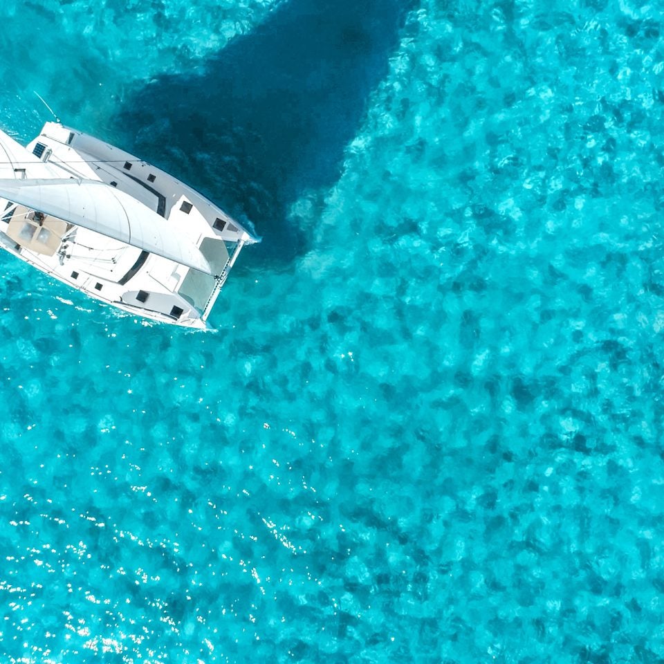 Vogelperspektive eines im strahlend blauen Wasser segelnden Dream-Yacht-Katamarans