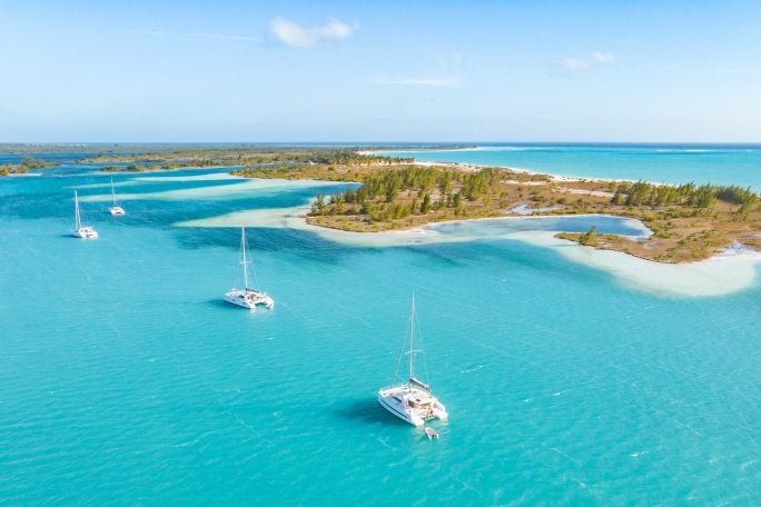 Vista de una línea de islas con tres catamaranes Dream Yacht en aguas azules