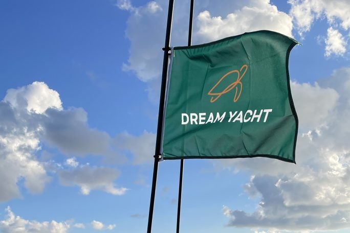 Dream Yacht branded flag waving against a blue sky.