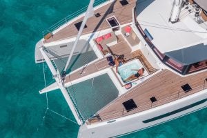 Unas personas descansando en la cubierta de proa del catamarán Alegria 67