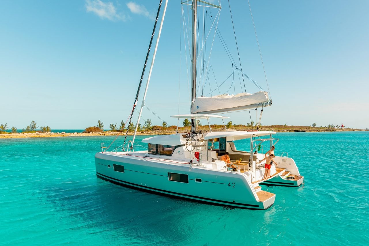 Catamarán a vela Lagoon 42 anclado cerca de una costa de arena