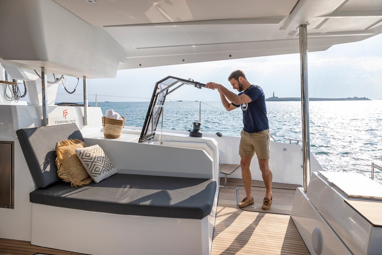 Un hombre entrando en el camarote desde la cubierta del catamarán Aura 51