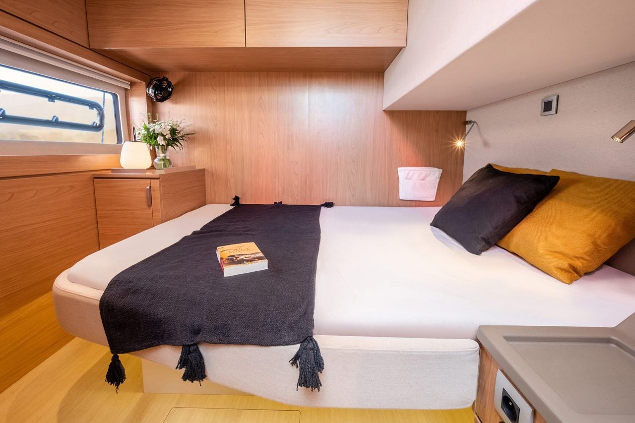 Ampia cabina in legno chiaro con letto matrimoniale a bordo di un catamarano Bali 4.8