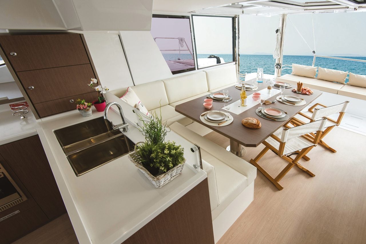 Salon on a Bali 4.6 with kitchen in foreground overlooking dining table with outdoor view