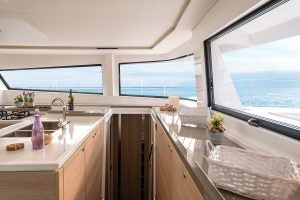 Grande cucina in legno chiaro con finestre panoramiche a bordo del Bali 5.4