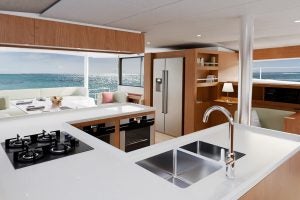 Grande cuisine en forme de U avec des détails en bois clair sur le bateau de luxe Bali 5.8