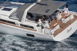 Vista del pozzetto della barca a vela Oceanis Yacht 54 con donna al timone