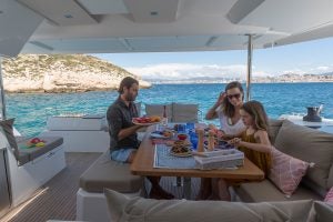 Una familia comiendo en el puente de mando del catamarán a vela Astrea 42