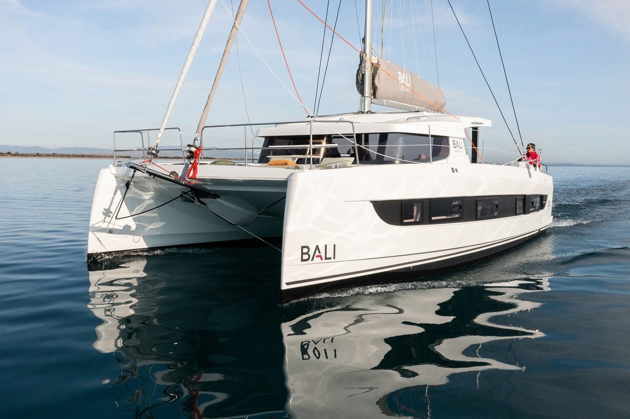 Uomo al timone di un catamarano a motore Bali CatSmart