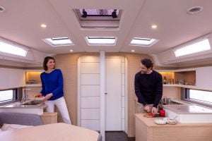 Couple en train de cuisiner dans la cuisine d’un monocoque à voile Dufour 44