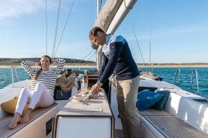 Man preparing food at the cockpit table on the Dufour 470 monohull