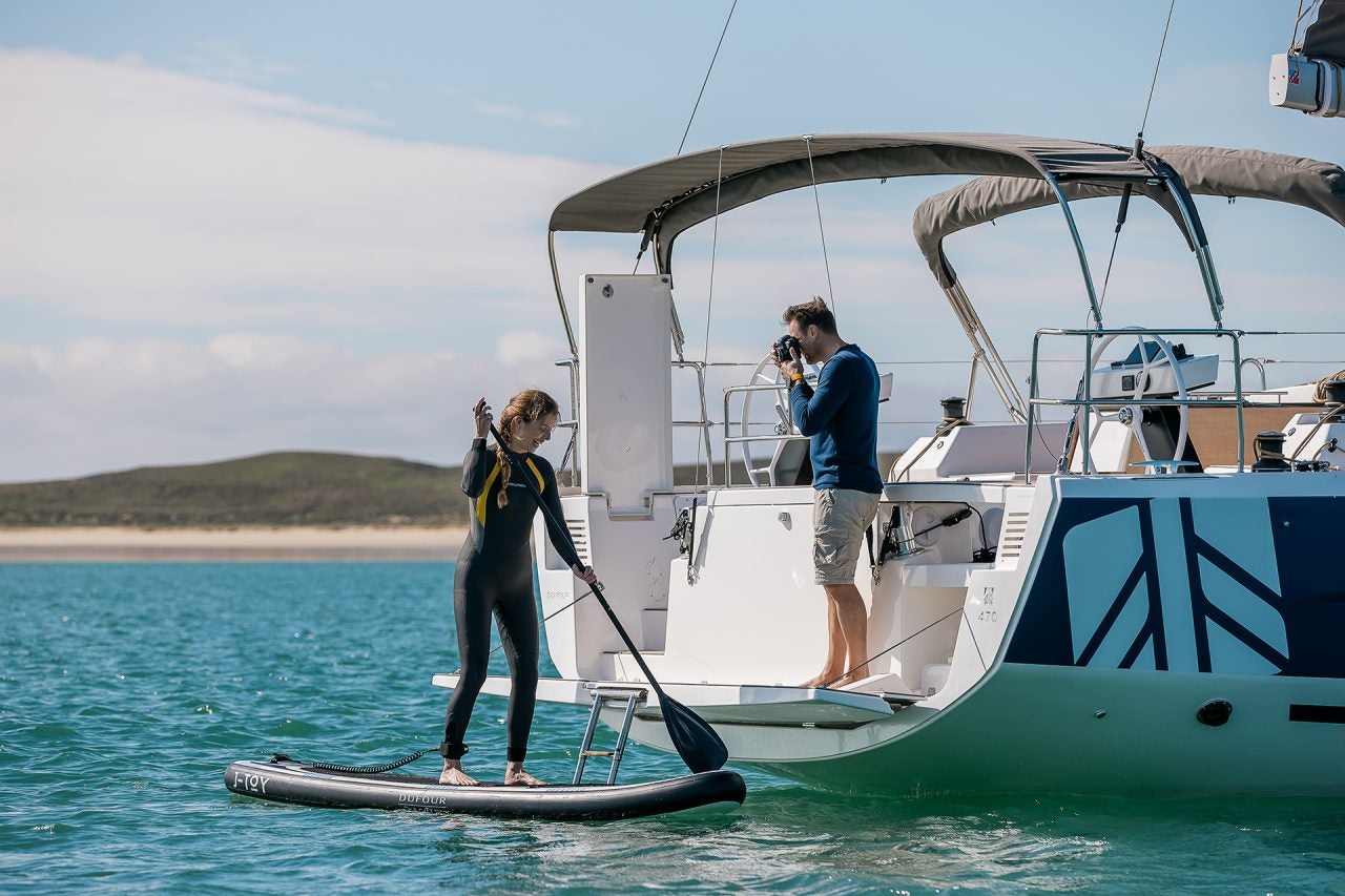 Couple using Dufour 470 sailing monohull swim platform for watersports