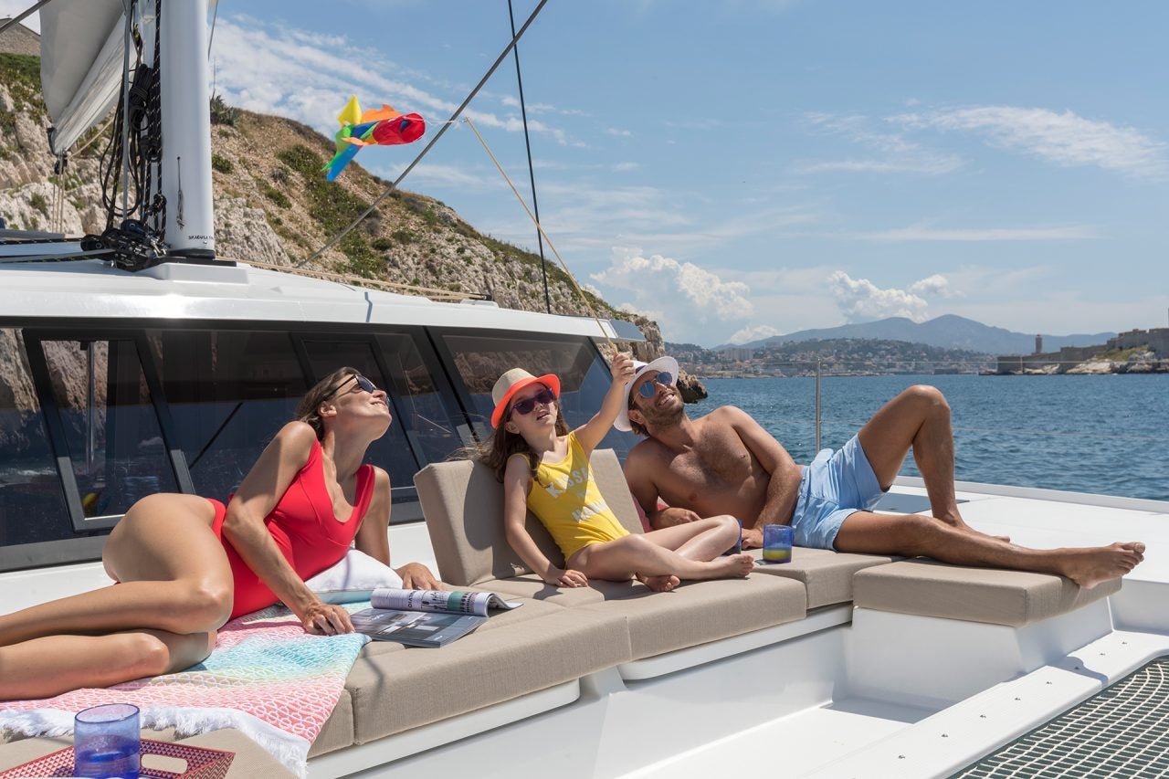 Family on the foredeck lounge of the Fountaine Pajot Astrea 42 catamaran