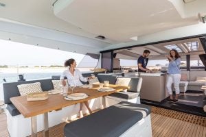 Mehrere Personen genießen den Cockpitbereich der Elektroyacht Fountaine Pajot Aura 51