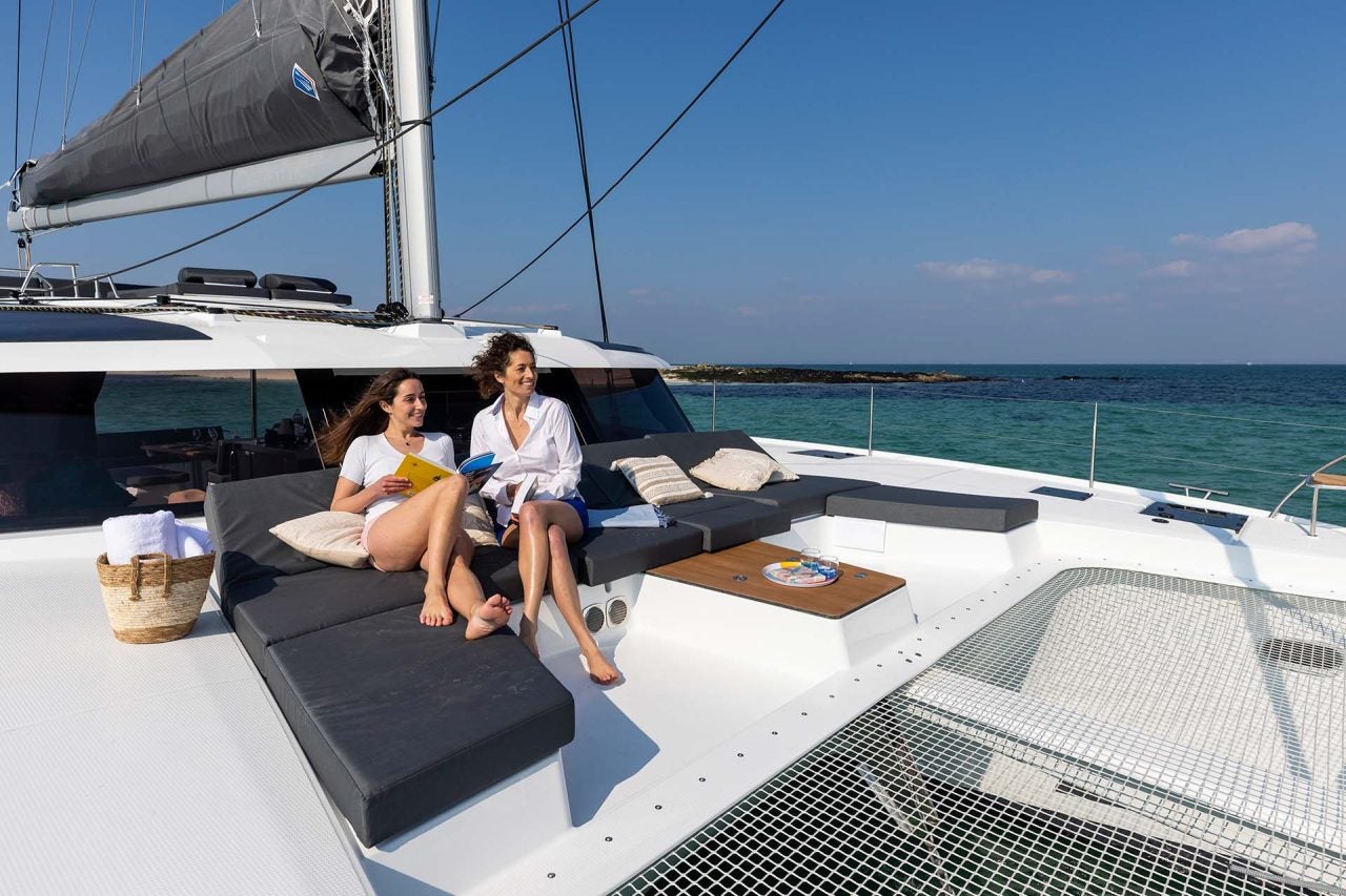 Women on front lounge of the Electric Fountaine Pajot Aura 51 sailing catamaran