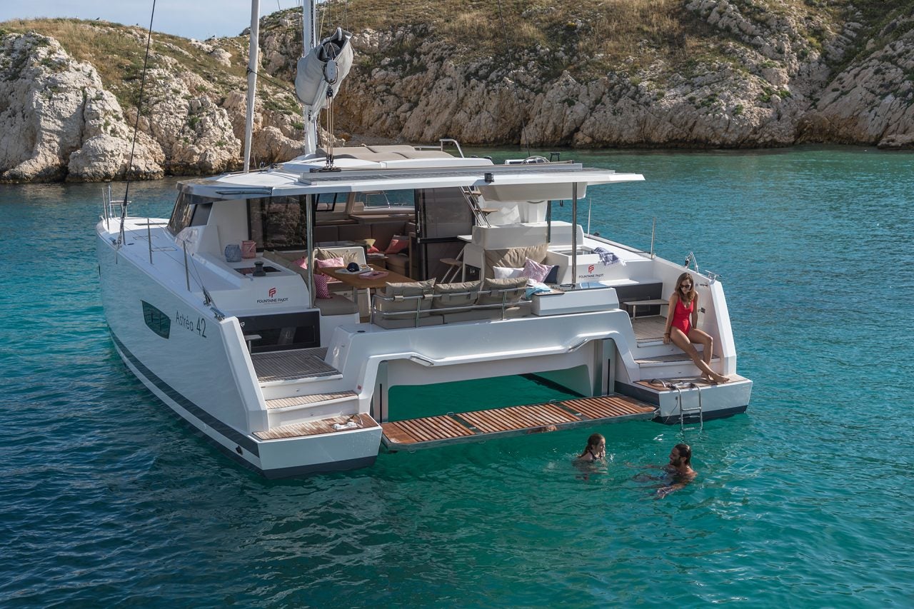 Catamarano Astrea 42 Smart Electric in rada vicino a una costa rocciosa