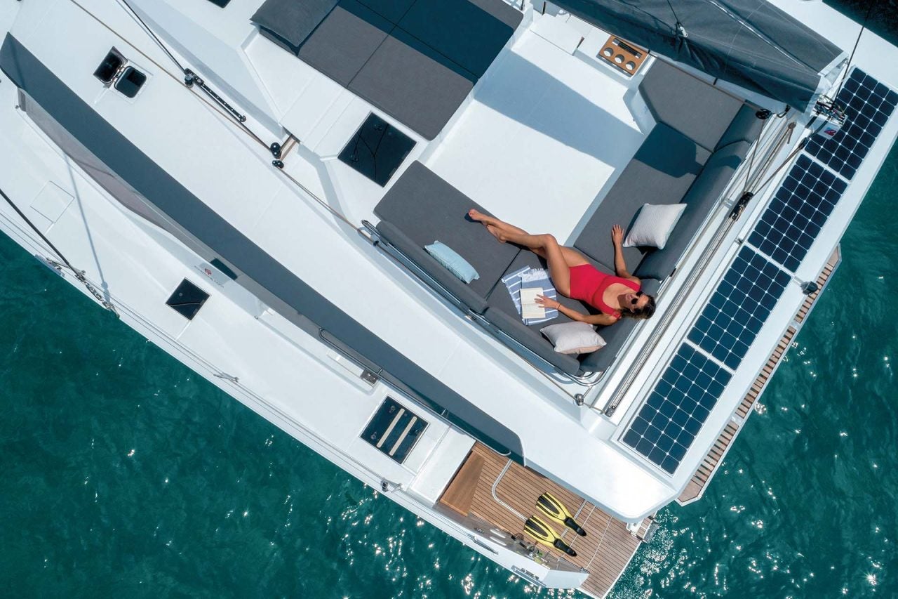 Vista superior de una mujer en la zona de estar del puente volante del catamarán eléctrico Elba 45