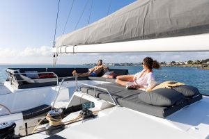 Couple on flybridge lounge area of the Fountaine Pajot Aura 51 electric catamaran