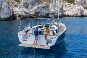 Electric Dufour 530 sailboat at anchor with people using outdoor grill