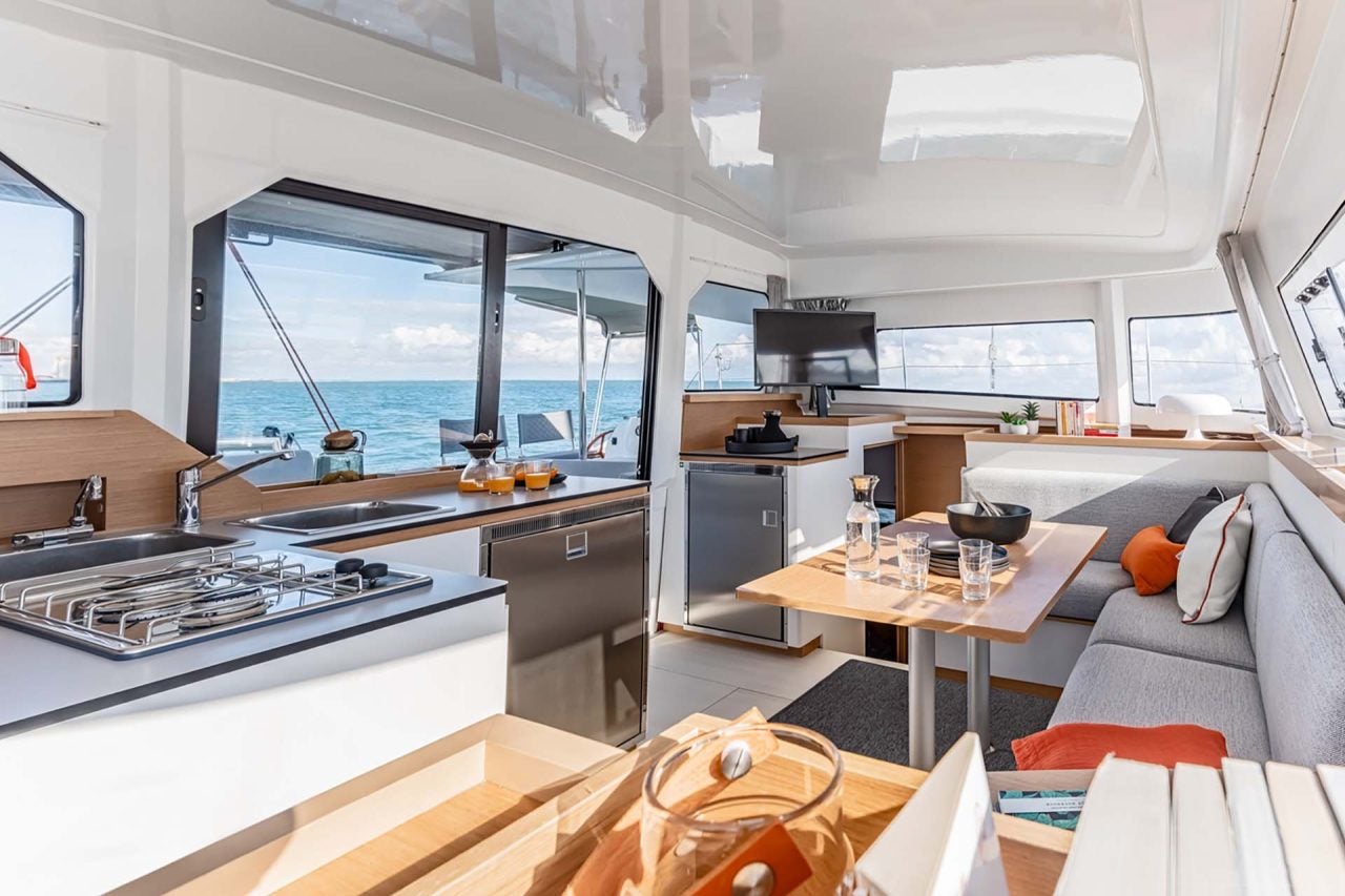 Salón del catamarán Excess 11 con zona de asientos y grandes ventanales