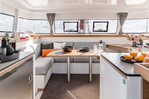 Zona de asientos del catamarán a vela Excess 11 con ventanas envolventes