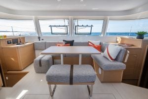 Espace de repas intérieur du catamaran Excess 14 avec des fenêtres enveloppantes