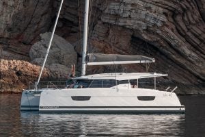 Isla 40 catamaran anchored near rocky cliffs