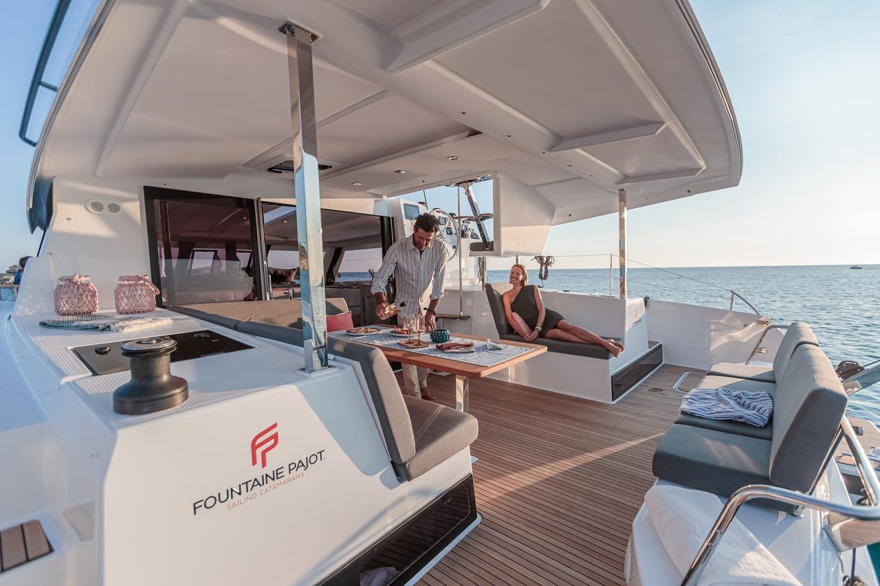 Mehrere Personen im Cockpit eines Luxus-Yachtmodells von Fountaine Pajot