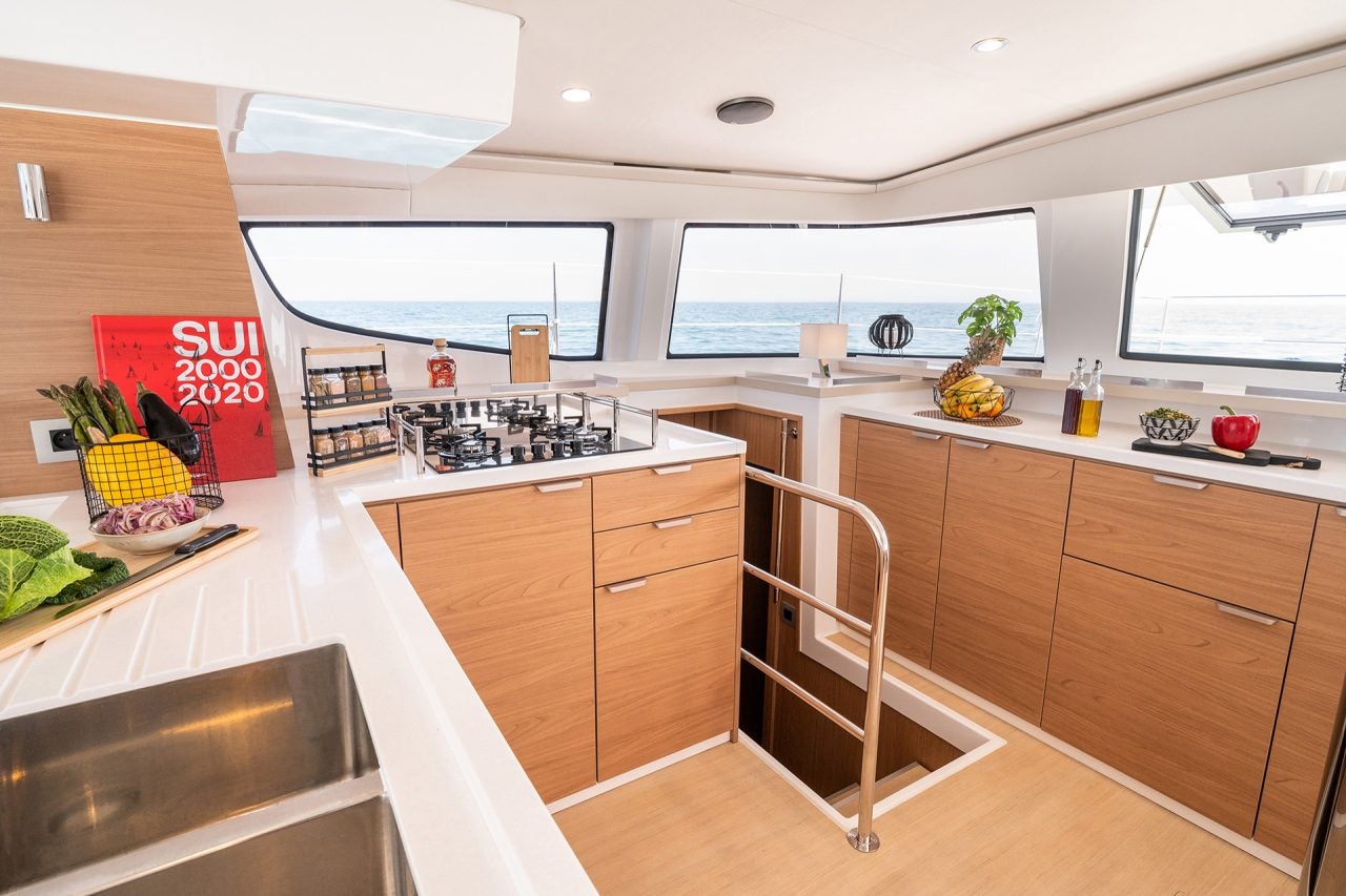 Large light wood kitchen with wrap around windows aboard the Bali 4.6