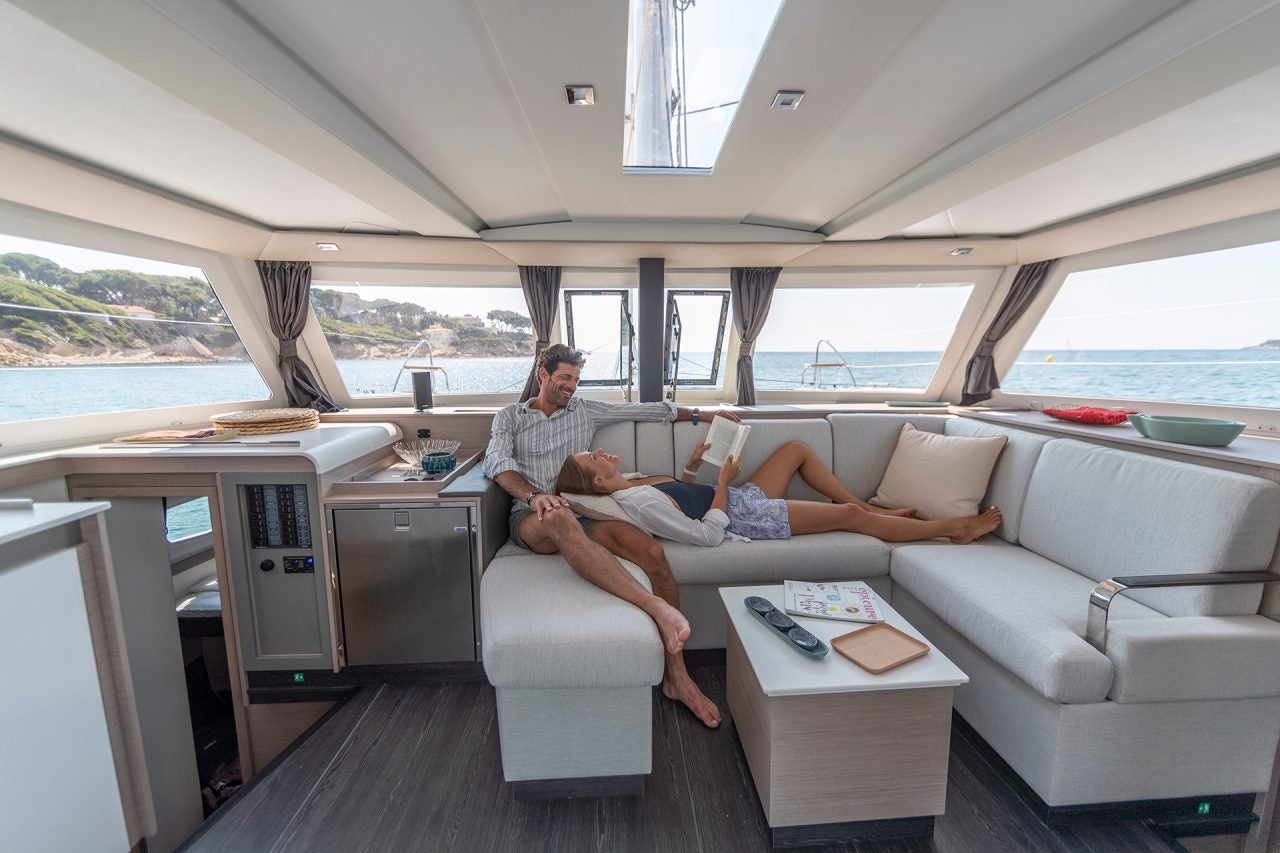 Couple seated in salon of the Fountaine Pajot 67 catamaran