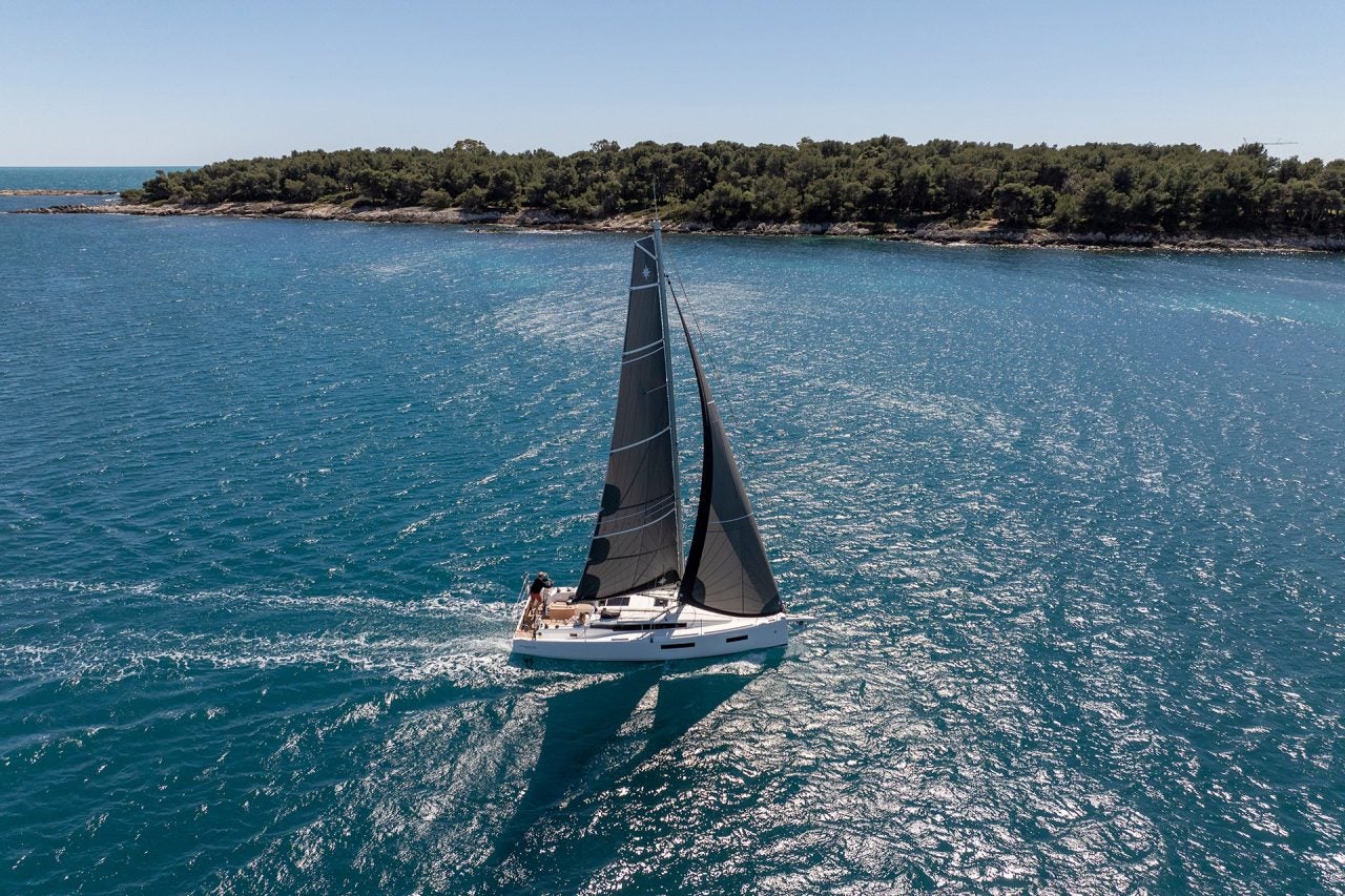 Das Einrumpfsegelboot Sun Odyssey 350 beim Segeln nahe der Küste