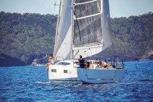 Monoscafo Sun Odyssey 410 in navigazione su uno sfondo di montagne verdi