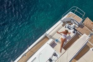 Femme se prélassant dans le cockpit du voilier Jeanneau Sun Odyssey 490