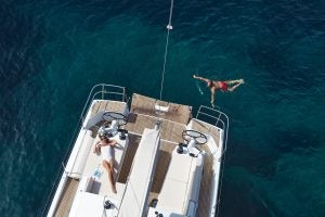 Woman swimming next to platform on the Sun Odyssey 490 monohull