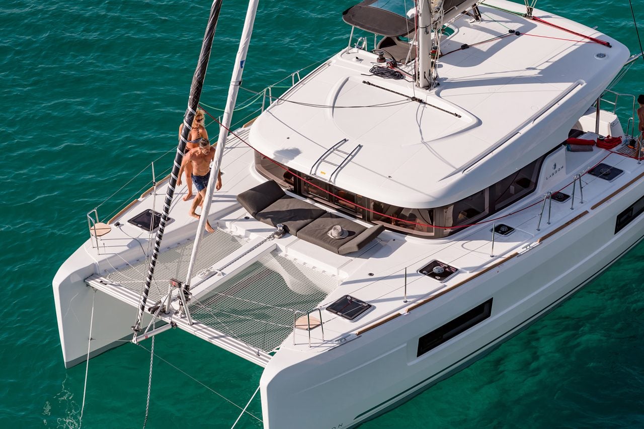 Una pareja caminando por la cubierta del catamarán a vela Lagoon 40