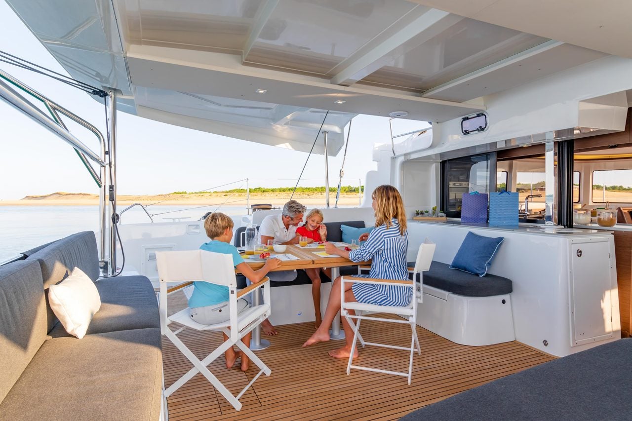 Eine Familie beim Essen im Freien an Bord des Katamarans Lagoon 46