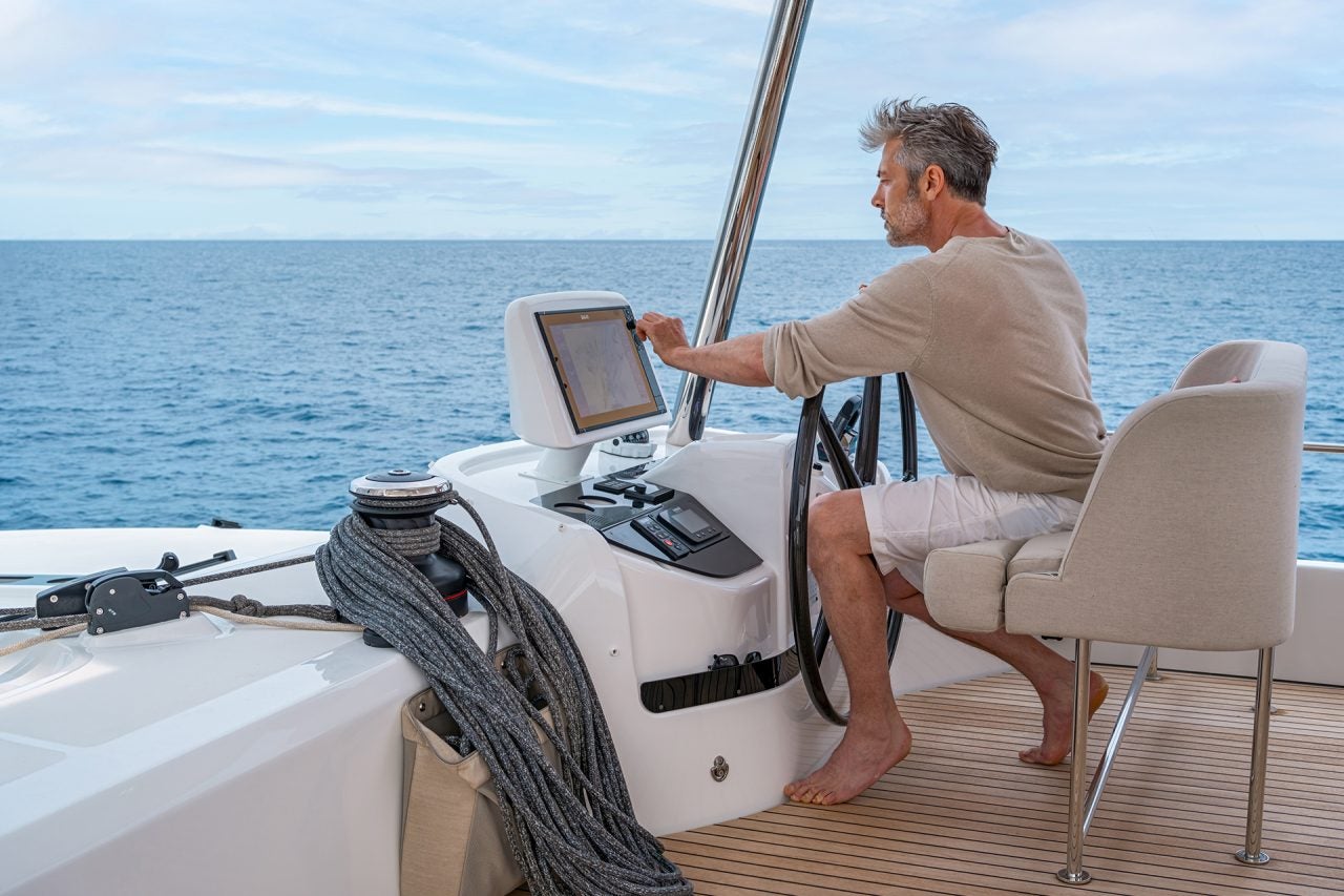 Uomo al timone dell'elegante catamarano Lagoon 55