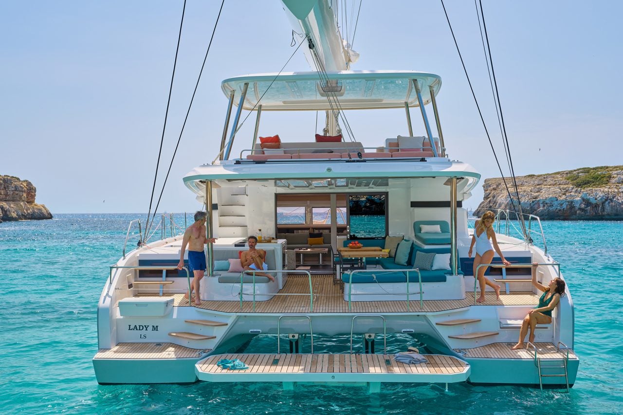 Vista posteriore delle persone a bordo dell'elegante catamarano Lagoon 55 in rada