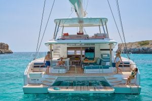 Vista posterior de unas personas a bordo del catamarán de lujo Lagoon 55 en el fondeadero